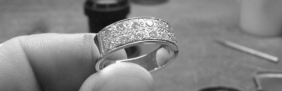A diamond band being pave-set by hand at the Oswestry Goldsmiths workshop bench